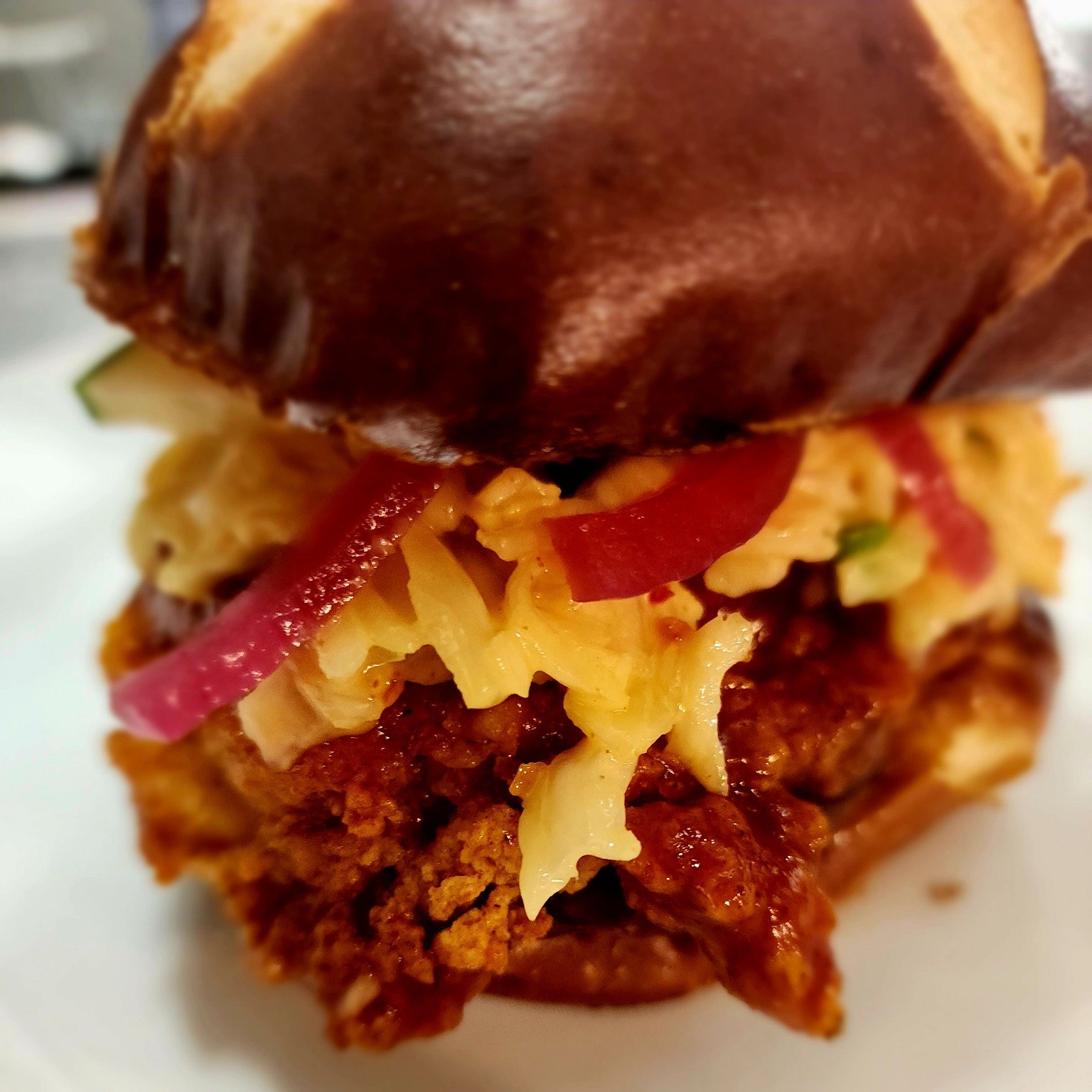 Breaded chicken sandwich on a pretzel bun
