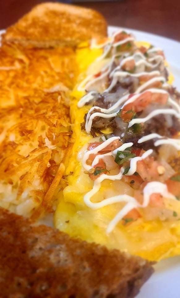 Southwest steak omelette topped with sour cream and pico