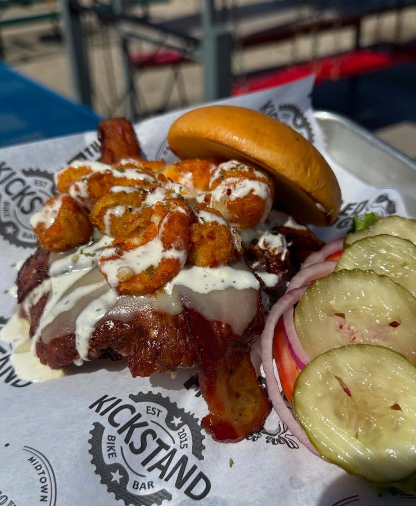 Crispy chicken sammy with lettuce, tomato, onion and pickle on a bun