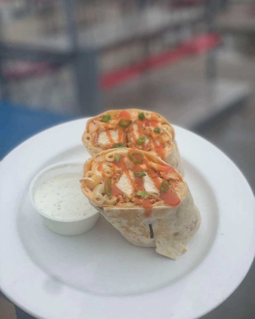 Buffalo chicken wrap sliced in half, served with a side of dressing
