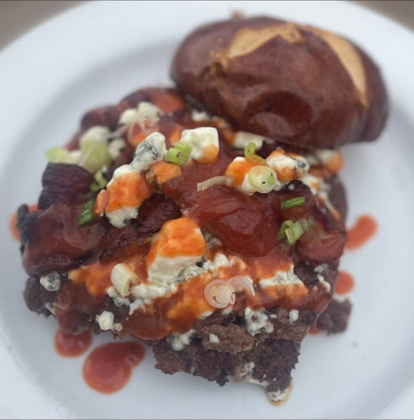 Black and bleu smash burger with bleu cheese crumbles, bacon and hot sauce